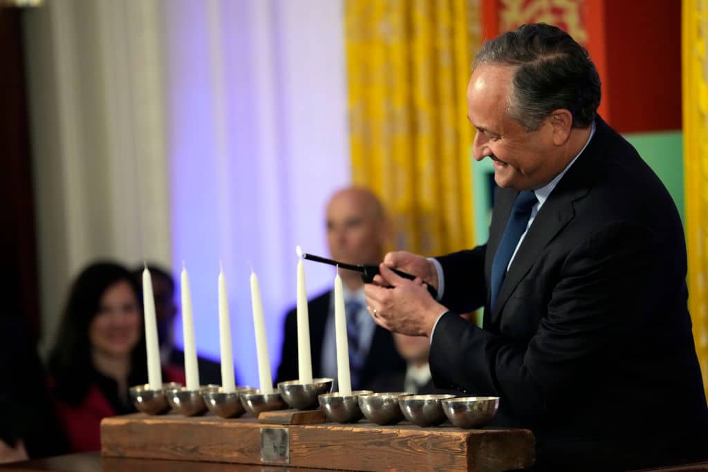 WASHINGTON, DC - DECEMBER 11: Second gentleman Doug Emhoff lights the Shamash during a Hanukkah reception in the East Room of the White House on December 11, 2023 in Washington, DC. President Biden and first lady Jill Biden host a reception to mark the Jewish holidays. (Photo by Jacquelyn Martin - Pool/Getty Images)