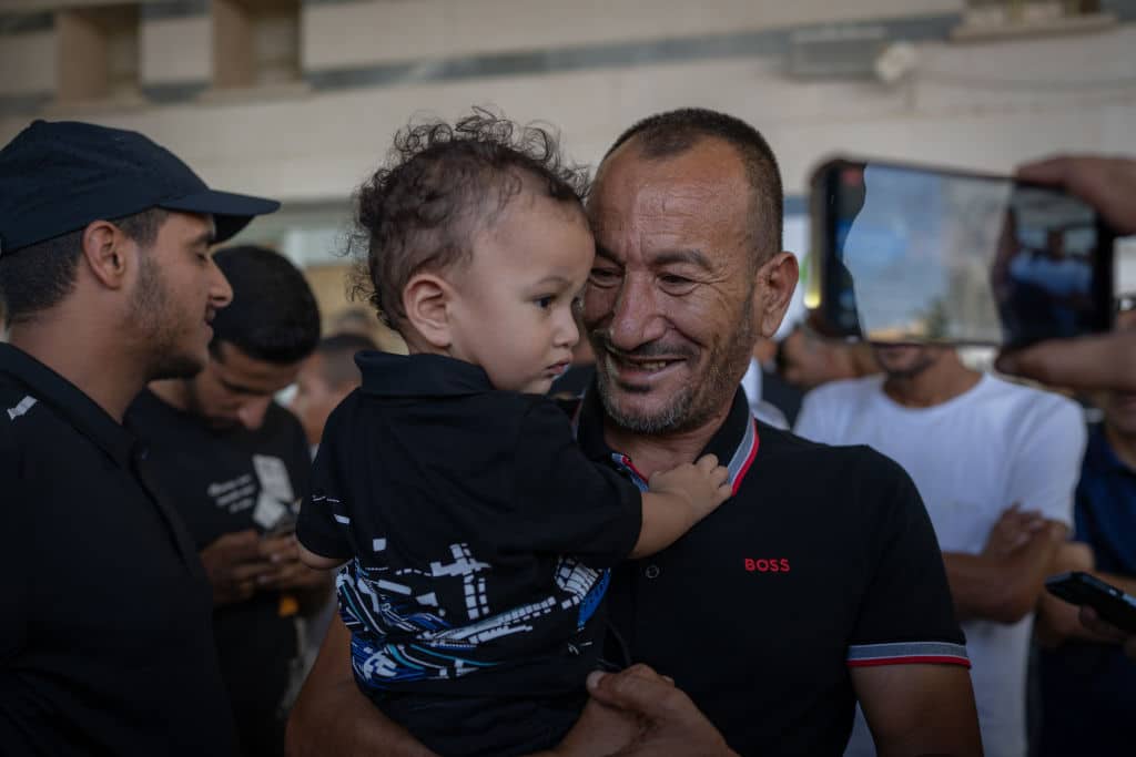 Brother of freed Israeli hostage Kaid Alkadi holds Alkadi's son as his relatives gather at the Medical Center in Beersheva in southern Israel. (Photo by Ilia yefimovich/picture alliance via Getty Images)