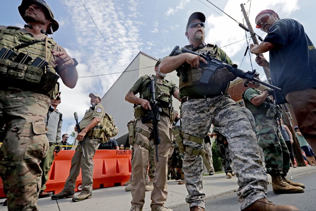 White nationalists, neo-Nazis and members of the "alt-right" with body armor and combat weapons evacuate comrades who were pepper sprayed after the "Unite the Right" rally was delcared a unlawful gathering by Virginia State Police August 12, 2017 in Charlottesville, Virginia.