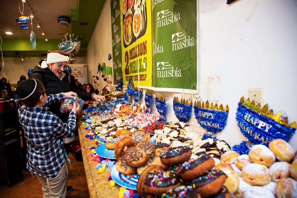 People look for food during a Hanukkah and menorah lighting gathering for divorced, widowed mothers and children at the food pantry organization Masbia in Brooklyn, New York on November 29, 2021.