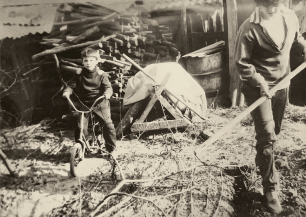 My father riding his bike while his mother tends to the crops, early 80s. In his town, it was common for families to have a patch of land to grow food for the winter.