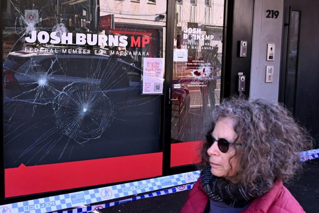 People pass the electoral office of Australian federal Labor Party member of parliament Josh Burns in the Melbourne suburb of St Kilda after police said at least five people smashed windows and painted slogans on the walls on June 19, 2024.